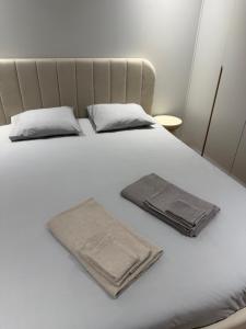 a white bed with two towels on top of it at Premium T1 - Sea & Coast in Espinho