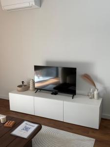 a living room with a tv on a white cabinet at Premium T1 - Sea & Coast in Espinho