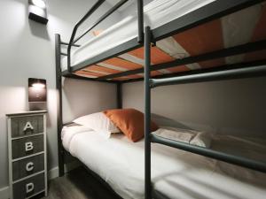 a bedroom with two bunk beds and a night stand at AC Apartaments Centre in Pas de la Casa