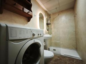 a washing machine in a bathroom with a toilet at AC Apartaments Centre in Pas de la Casa