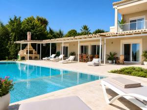 a villa with a swimming pool and a house at Nina Apartment in Ágios Márkos