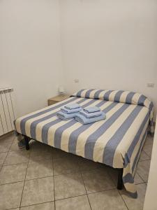 a bed with two blue towels on top of it at Garibaldi 39 in Loano