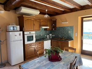 a kitchen with a table and a white refrigerator at Douceur Meyralaise in Meyrals