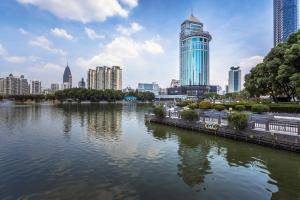 eine Skyline der Stadt mit einem Fluss und Gebäuden in der Unterkunft Wuhan Jin Jiang International Hotel in Wuhan