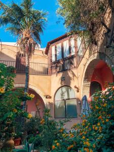 a building with a palm tree in front of it at Antica Corte delle Ninfee, Historical Private Villa in Trapani