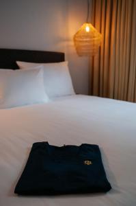 a black bag sitting on top of a white bed at gambino hotel GOETHE26 in Munich