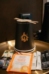 a table with a cup with chopsticks and books on it at gambino hotel GOETHE26 in Munich +1 photo