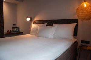 a bedroom with a bed with white sheets and pillows at gambino hotel GOETHE26 in Munich