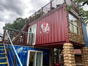 a red house with a balcony on top of it at S2 Ft Sill Sky Stack-City View Suite 8-NA PPI SE in Medicine Park