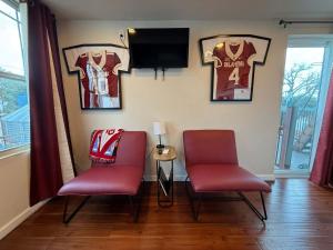 a room with two chairs and jerseys on the wall at S2 Ft Sill Sky Stack-City View Suite 8-NA PPI SE in Medicine Park +36 photos