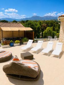a group of chairs and lounge chairs on a patio at villa plaisirs in Saint Paul de Vence