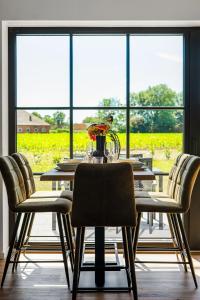 ein Esszimmer mit Tisch und Stühlen und einem Fenster in der Unterkunft Neu! Auszeit an der "Grenzfarm" - Stilvolle und geräumige FeWo - perfekt für Radfahrer und Familien in Nordhorn
