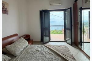 a bedroom with a bed and a sliding glass door at Panoramic Sea view Deluxe Apartment in Joppolo in Ioppolo