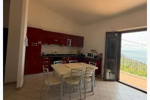 a kitchen with a table and chairs and a balcony at Panoramic Sea view Deluxe Apartment in Joppolo in Ioppolo +24 photos