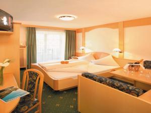 a hotel room with two beds and a desk at Parkhotel Plauserhof in Plaus +35 photos