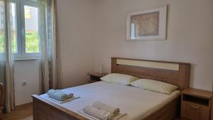 a bedroom with a bed with two towels on it at Apartment Keti - Mandre in Mandre