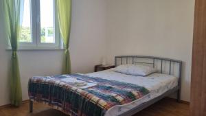a bed in a bedroom with a window at Apartment Keti - Mandre in Mandre