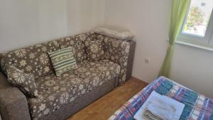 a couch sitting in a living room next to a window at Apartment Keti - Mandre in Mandre