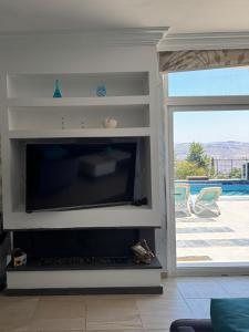 a living room with a fireplace with a flat screen tv at Luxury Farm Villa with Private Pool in Jerash