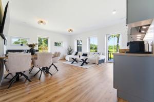 eine Küche und ein Wohnzimmer mit Tisch und Stühlen in der Unterkunft Neu! Auszeit an der "Grenzfarm" - Stilvolle und geräumige FeWo - perfekt für Radfahrer und Familien in Nordhorn