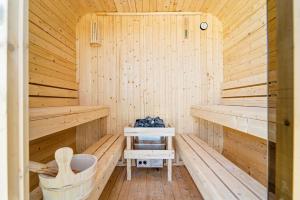 eine Holzsauna mit Sitzbank und Waschbecken in der Unterkunft Neu! Auszeit an der "Grenzfarm" - Stilvolle und geräumige FeWo - perfekt für Radfahrer und Familien in Nordhorn + 193 Fotos