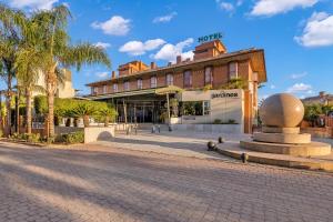 a street in front of a building with a sculpture at Spa Jardines de Lorca in Lorca