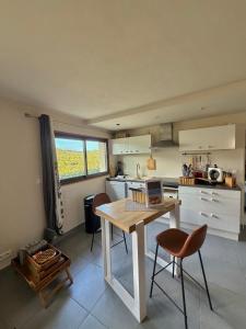a kitchen with a table with a laptop on it at T2 entre Mer et Montagnes in Porto-Vecchio