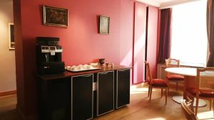 a room with a red wall with a coffee maker on a counter at Suite Stays Bruges - Pandreitje 6 in Bruges +32 photos
