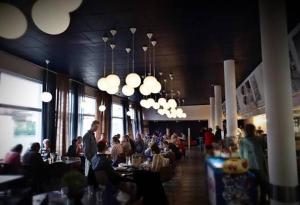 a group of people sitting at tables in a restaurant at Hotel Lahnajärvi in Lahnajärvenkylä