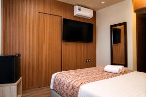 a hotel room with a bed and a flat screen tv at Dakhla Sur Mer Hôtel in Dakhla