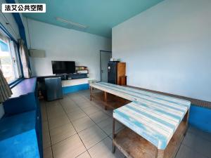 a room with a table and a refrigerator at 法艾民宿 in Yeh-yin