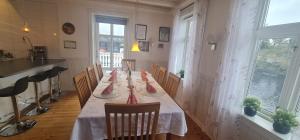 a dining room with a long table with red napkins on it at Boat Included, Waterfront Villa, Near Bergen in Lindås
