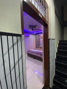 a room with a bed and a staircase with purple lights at Samrat Hotel in Sonīpat