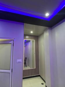 a room with purple lights on the ceiling and a chair at Samrat Hotel in Sonīpat