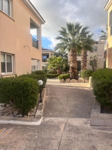 a parking lot in front of a building with palm trees at Tala Rivera Paradise in Tala