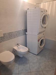 a bathroom with a toilet and a washing machine at Casa Levante in Brugnato