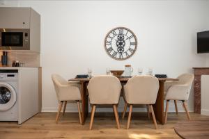 a dining room table with chairs and a clock on the wall at La Suite Cacao in Saint-Rambert-dʼAlbon +16 photos