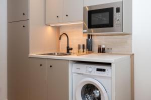 a kitchen with a washing machine and a sink at La Suite Cacao in Saint-Rambert-dʼAlbon