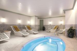a spa room with a hot tub and lounge chairs at The Reserve at Park MGM in Las Vegas