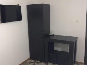 a black refrigerator and a table in a room at Pensiunea Marcello in Iaşi