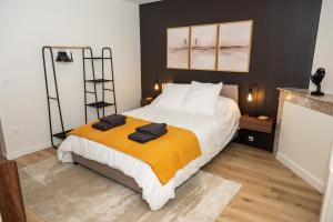 a bedroom with a bed with an orange blanket at La Suite Cacao in Saint-Rambert-dʼAlbon