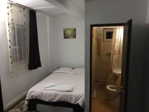 Habitación pequeña con cama y baño. en Pensiunea Marcello, en Iaşi