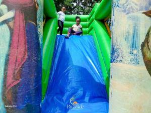 a little girl sitting on top of an inflatable slide at Riverside chania resort in Nyeri