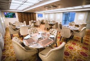 a dining room with tables and chairs in a restaurant at Dhaka Unique Regency in Dhaka