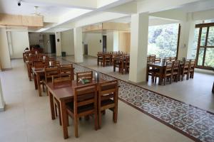 a dining room with wooden tables and chairs at Harela Inn - A Boutique Himalayan Wedding Retreat in Chamoli