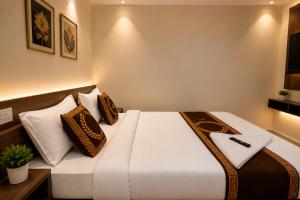 a hotel room with a bed with pillows at Hotel Namah Prime Near By Chanda Nagar Ameenpur Road in Hyderabad