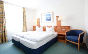a bedroom with a bed and a chair and a desk at Schuhbauers Oberwirt - digitale Self-Check-in Apartments in Schnotting