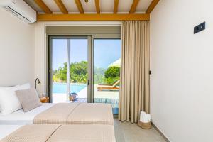 a bedroom with a bed and a view of a pool at Villa Emanouill Nopigia in Kissamos