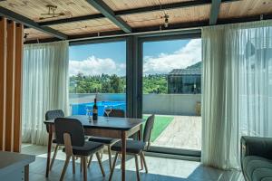 a dining room with a table and chairs and a large window at ANDE Apartments Hotel in Gonio