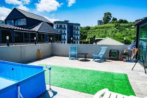a patio with a pool and two chairs and a table at ANDE Apartments Hotel in Gonio
